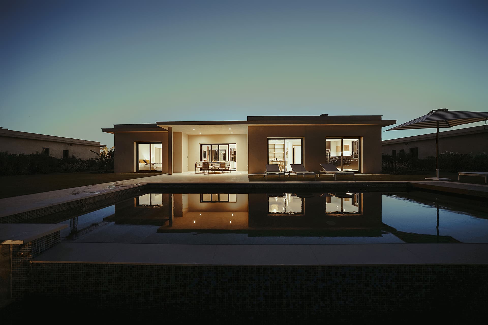 Maison moderne avec piscine éclairée la nuit Maison moderne avec piscine éclairée la nuit